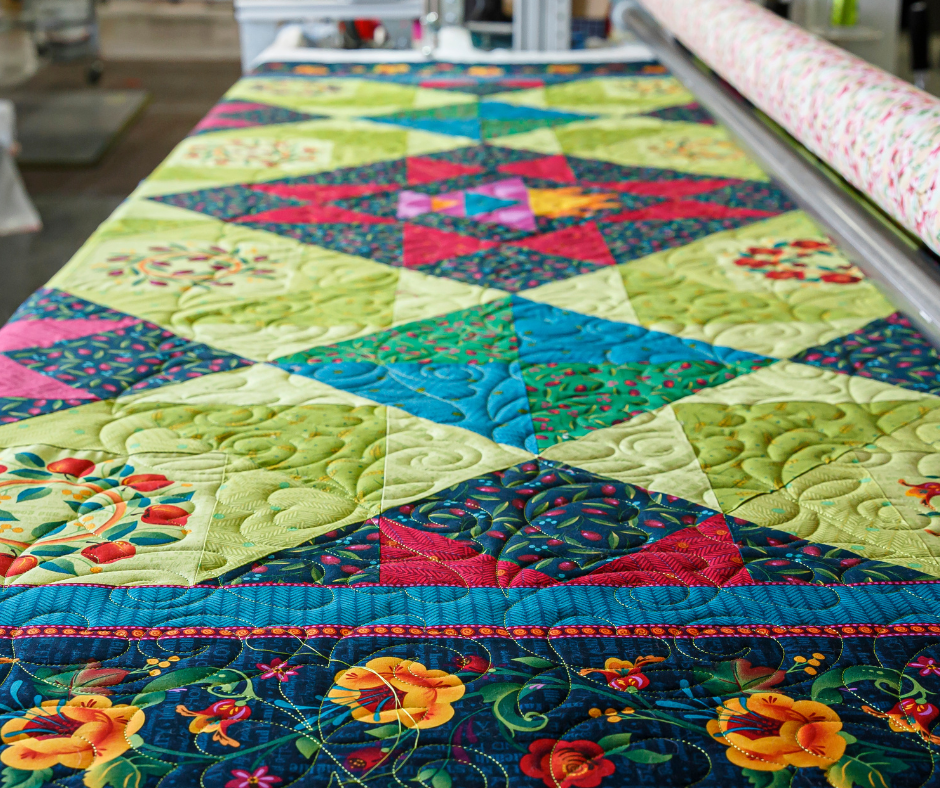 a colorful quilt top being machine quilted at Missouri Star.