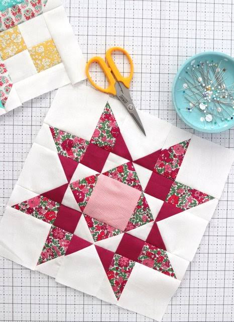 Fabric scissors, shears and thread snips laid out on quilting cotton