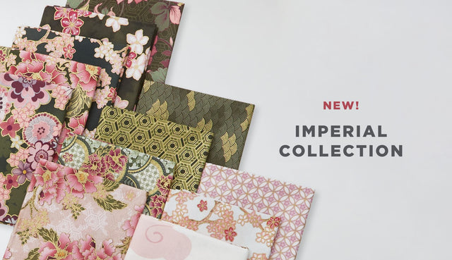 A selection of fat quarter fabrics featuring cranes, flowers, and geometric prints in a plum palette, with metallic accents. 