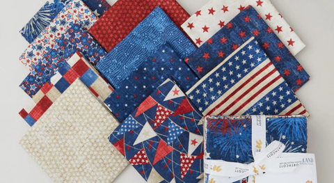 A selection of patriotic fat quarter fabric prints in Red and blue mixed with beige.