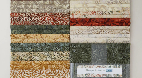 Layer cake of nature print batiks in rust, gold, green, brown, and cream from the Changes in Seasons fabric collection.