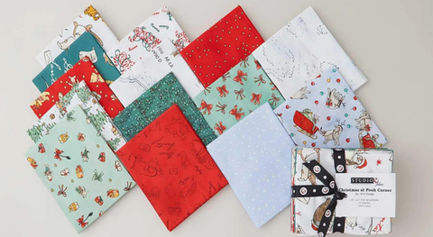 Fat quarter bundle of cotton quilting fabric featuring Winnie the Pooh characters at Christmastime.