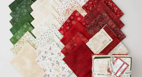 Fat quarter bundle of Christmas and winter prints in a red, green, and cream palette.