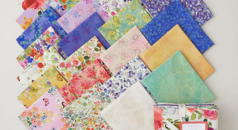 A selectin of quarter fabrics featuring floral prints in bright colors including pink, green, yellow, and purple.