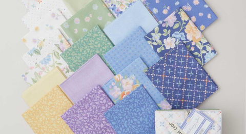 Fat quarter bundle of cotton quilting fabric with batik florals in a blue, green, and purple palette.