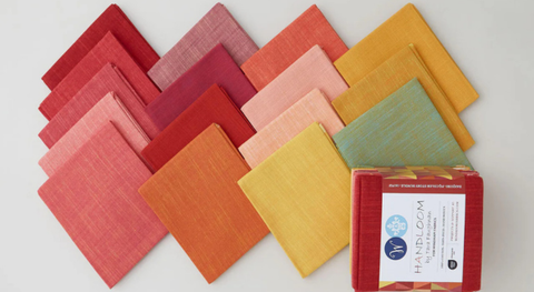 Fat quarter bundle of yarn-dyed cottons in shades of red, orange, and gold. 