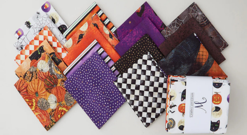 Fat quarter bundle of Halloween motifs in an orange, black, and purple palette.