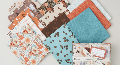 a selection of fat quarter fabrics featuring flowers, coffe cups, and coffee beans. They are from the Perfect Blend fabric collection from Clothworks.