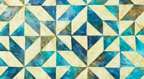 108"-wide cotton quilt fabric with a batik print of blue and putty quilt blocks.