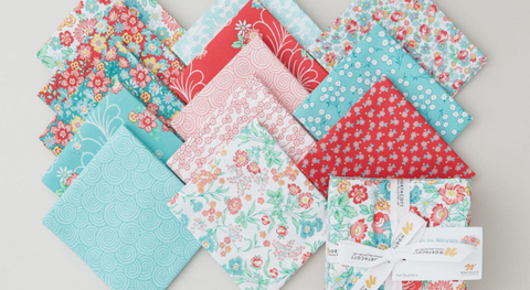 Fat quarter bundle of floral prints and scrolls in a pink, red, and turquoise palette.