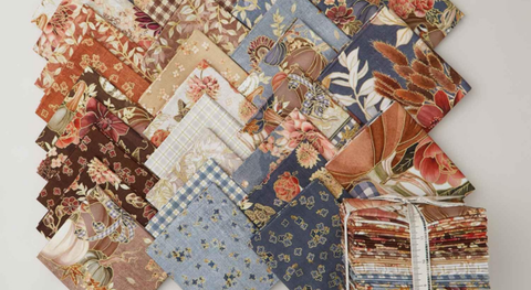 Fat quarter bundle of brown, blue, orange, and cream quilting fabric with gold metallic accents. 