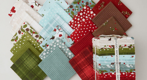 Fat quarter bundle of flannel, winter-themed prints in red, blue, green, brown, and cream. 