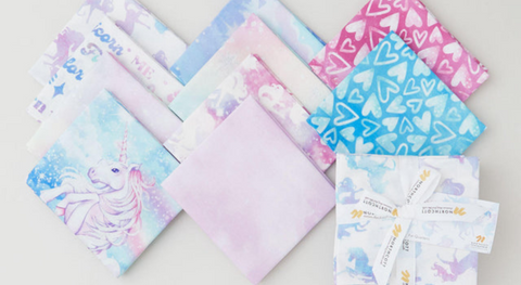a fat quarter bundle of pretty pastel fabrics with hearts and unicorns from the sparkle magic fabric collection.