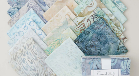 a selection of fat quarter fabrics featuring pretty beach inspired batik prints in soothing shades of blue, green and cream.