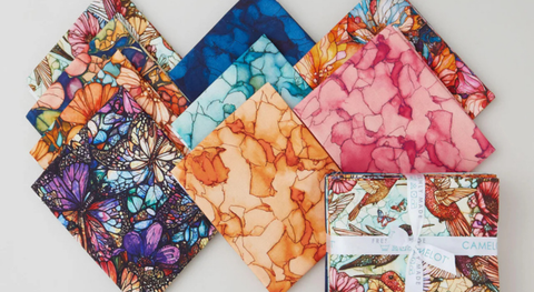 a selection of fat quarter fabrics with vibrant watercolor-like prints of  birds, butterflies, and more.