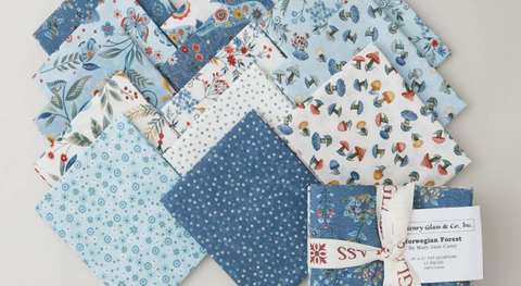 a selection of fat quarter fabrics featuring animals and foliage in a blue and cream palette.