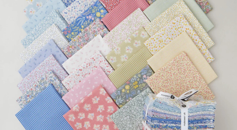 a selection of fat quarter fabrics in small floral prints and gingham, in shades of blue, green, pink, and yellow