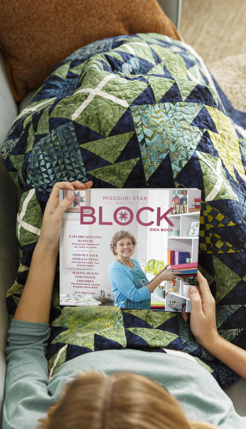Person reading a BLOCK magazine issue with a quilt